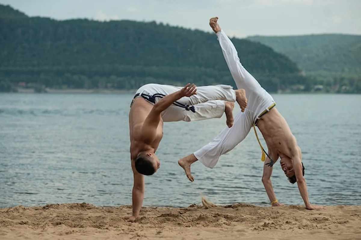 Mężczyźni trenują capoeira na plaży