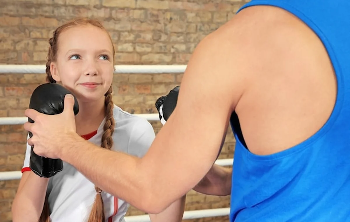 Mała dziewczynka z trenerem na bokserskim pierścionku