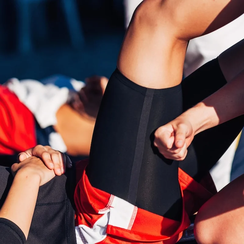 Terapeuta sportowy masażujący nogę sportowca