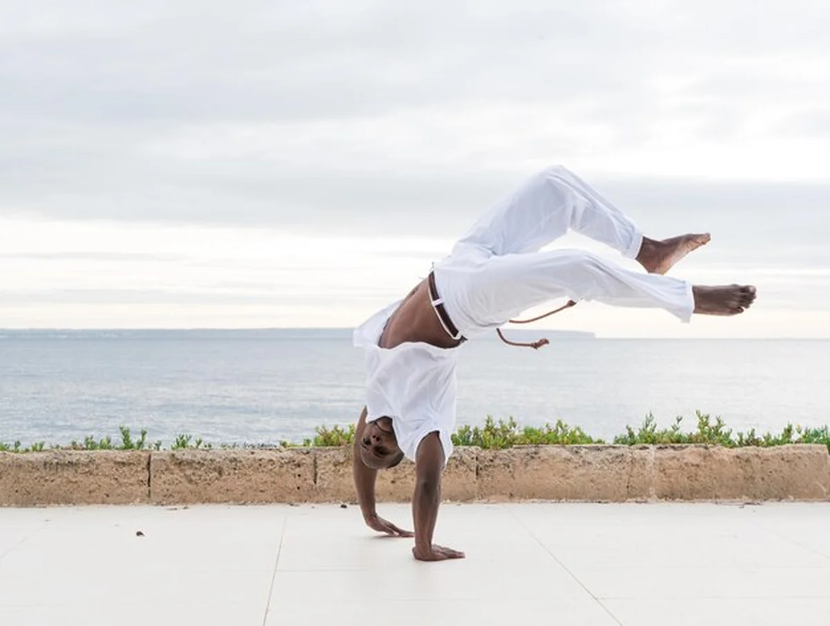 Capoeira wykonuje akrobatyczne ruchy na świeżym powietrzu