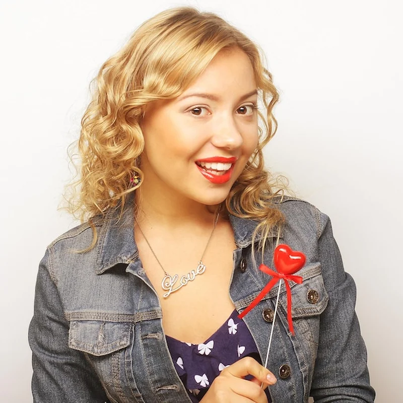 Blond kobieta trzyma czerwone serce